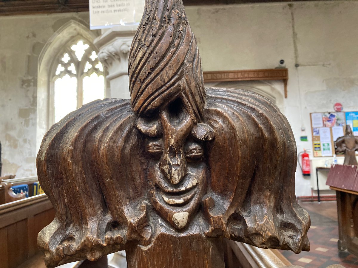A wooden statue of a clown Description automatically generated